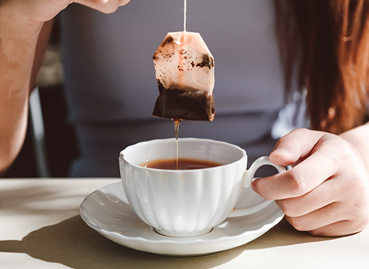 Teebeutel wird aus Teetasse gezogen